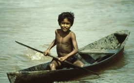 Amazonian boy in a dugout canoe